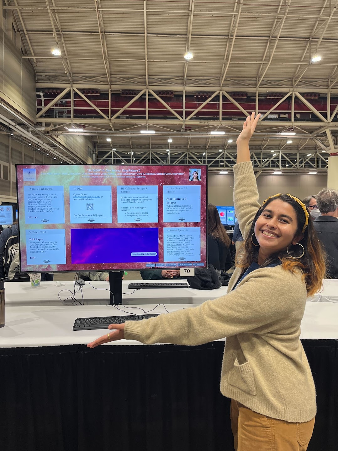 Noor Aftab in front of the AAS poster.